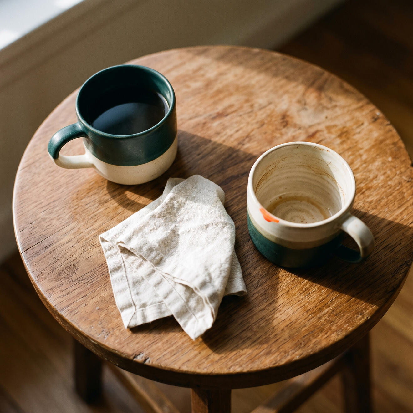 Dos tazas sobre una mesa, una llena y otra vacía